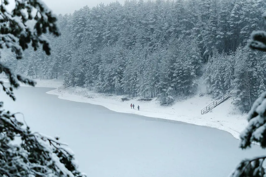 People walking in snow covered lake..